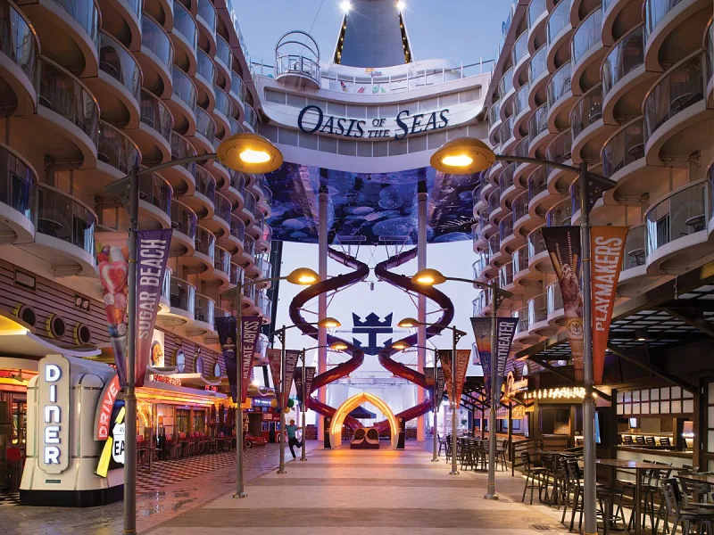 10 redenen waarom New York en een Caribbean cruise de perfecte combinatie zijn. Winkels, restaurants en gezellige sfeer in de Royal Promenade van de Oasis of the Seas