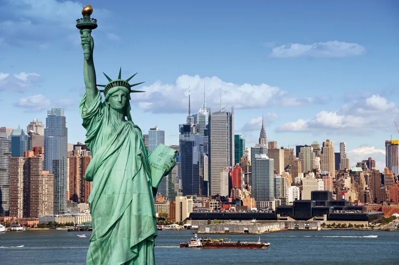 10 redenen waarom New York en een Caribbean cruise de perfecte combinatie zijn. Vrijheidsbeeld gezien vanaf een cruiseschip dat New York verlaat richting de Atlantische Oceaan